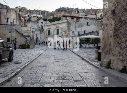 Matera, Italien, 14. September 2019: Touristen bei einem Spaziergang auf der Straße mit Kopfsteinpflaster in der Sassi di Matera ein historisches Viertel in der Stadt Matera. Bas Stockfoto