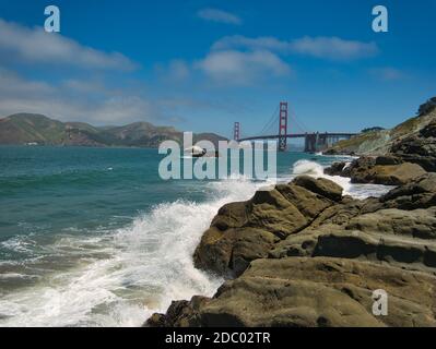 Eine felsige Küste mit der roten Golden Gate Bridge Der Hintergrund Stockfoto