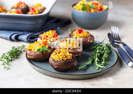 Gebackene gefüllte portobello-Pilze mit Bulgur-Pilaf und gehacktem Gemüse. Leckeres und nahrhaftes vegetarisches Gericht. Stockfoto