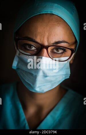 Farbportrait einer jungen Medizinerin mit Maske und Brille, Illustration für die Coronavirus Covid-19 Pandemie. Stockfoto