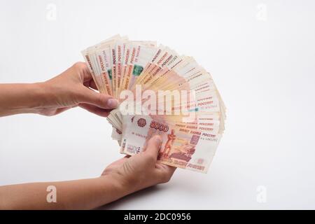 Die Hand zeigt im Rahmen den Geldbetrag In einem Bündel von Rechnungen Stockfoto