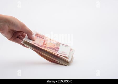 Hand hält ein Bündel von fünftausendsten russischen Banknoten aus Stockfoto