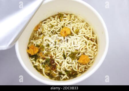 instant Nudeln, Nudelsuppe in einer Tasse, Blick von oben. Instant-Nudeln werden in einem vorgekochten und getrockneten Nudelblock mit Aromapulver und/oder Gewürzöl verkauft. Stockfoto