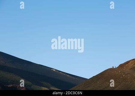 Sizilien, Italien. Touristen machen den steilen Aufstieg auf den Silvestri Superiori Krater in der Nähe des Gipfels des Ätna. Stockfoto