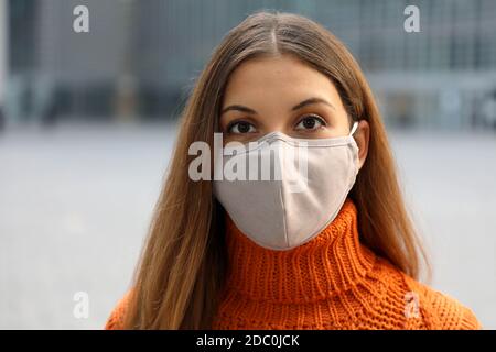 Nahaufnahme des Mädchens trägt Gesichtsmaske posiert in der Street Looking auf Kamera Stockfoto