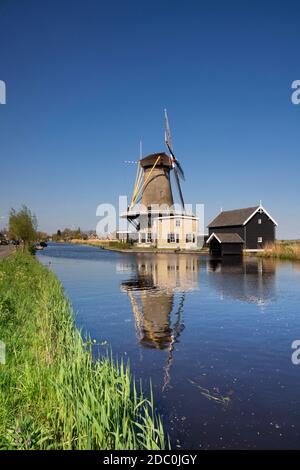 Blick über den Graafstroom zur Windmühle De Vriendschap Im Dorf Bleskensgraaf an einem klaren und knackigen Tag Im Frühling Stockfoto