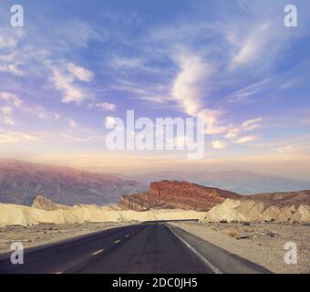 Wüstenstraße, die durch den Death Valley National Park bei Sonnenuntergang führt, Kalifornien USA. Stockfoto