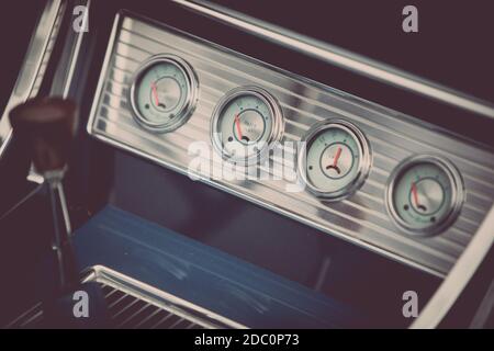 Farbe Nahaufnahme eines Kühlmittels, eine Uhr und andere verschiedene Anzeigen auf einem Oldtimer Armaturenbrett. Stockfoto