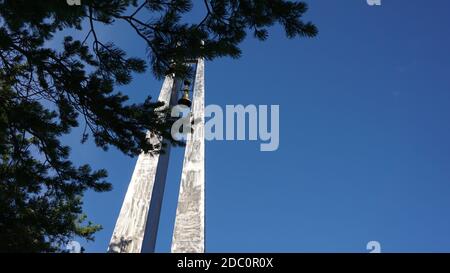 Kriegsdenkmal mit Glocke mit Kiefernzweigen Stockfoto