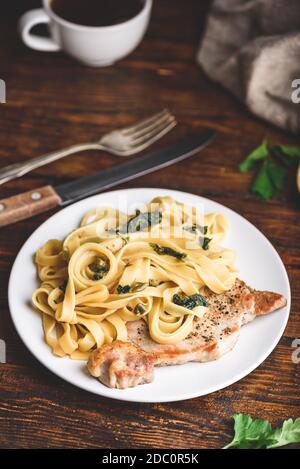 Schweinekotelett und Tagliatelle mit Kapern und Zitronenschale Stockfoto