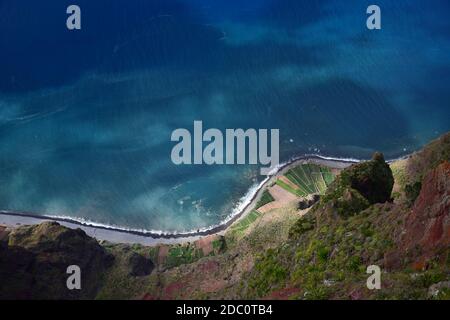 Der Blick vom beliebten Aussichtspunkt Cabo Girao hinunter auf den atlantik, den Strand und einige landwirtschaftliche Felder. Madeira, Portugal. Stockfoto