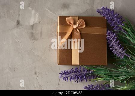 Quadratische Geschenkbox und Lavendelbukett auf grauem Hintergrund, Draufsicht Stockfoto