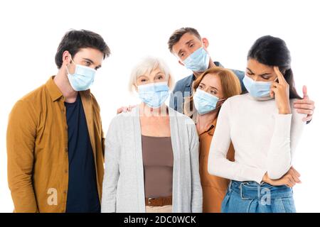 Traurige multiethnische Menschen in medizinischen Masken isoliert auf weiß stehen Stockfoto