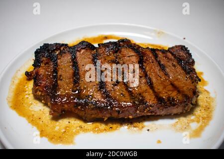 Ein perfekt gegartes Steak mit Grilllinien, die auf einem Reiner Weißer Hintergrund Stockfoto