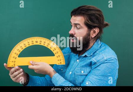 Mann überrascht mit Größe gemessen auf Winkelmesser Lineal Mathematik Werkzeug, Schule Stamm Disziplinen. Stockfoto