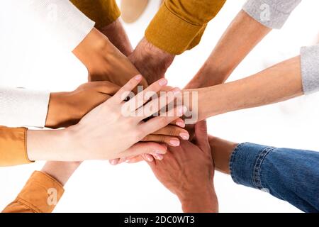 Draufsicht auf multiethnische Menschen, die Hände isoliert auf Weiß halten Stockfoto