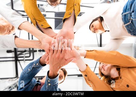 Grundansicht multikultureller Menschen, die Hände halten und lächeln Unscharfer Hintergrund Stockfoto