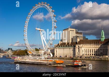 GPS Marine Schlepper GPS Cambria zieht eine Barge auf der Themse. London, Großbritannien. Flussverkehr für die Wirtschaft. London Eye und County Hall am Flussufer Stockfoto