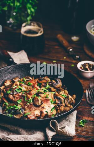 Gebratenes Schweinehals Steak mit verschiedenen Pilzen Gusseisen Pfanne Stockfoto