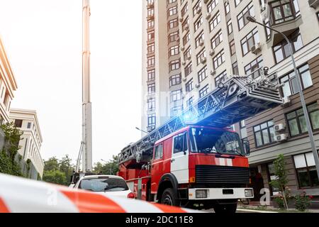 Viele Feuerwehrfahrzeuge mit Leiter und Sicherheitsausrüstung bei Unfall in Hochhaus Turm Wohnwohnung oder Bürogebäude in Stadtzentrum Stockfoto