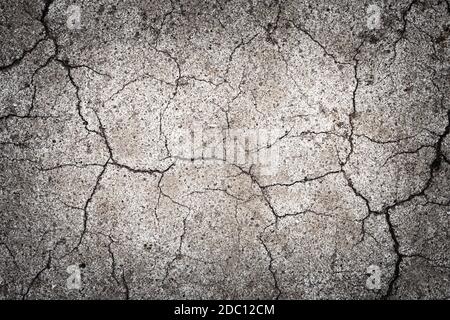 Textur mit Rissen alter Farbe auf dem Bürgersteig. Rissige Oberfläche einer Straßenmarkierung Hintergrund. Abstrakter Hintergrund mit einer mit Rissen bedeckten Oberfläche Stockfoto