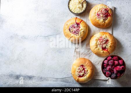 Hausgemachte süße Hefegebrüse gefüllt mit Beeren und mit Krümel. Betonboden. Stockfoto