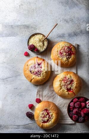 Hausgemachte süße Hefegebrüse gefüllt mit Beeren und mit Krümel. Betonboden. Stockfoto