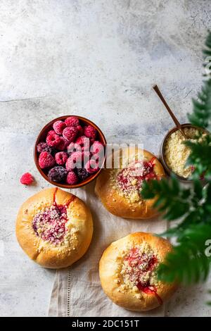 Hausgemachte süße Hefegebrüse gefüllt mit Beeren und mit Krümel. Betonboden. Stockfoto