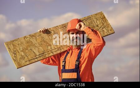 Provisorische Ausrüstung oder Strukturen zusammenbauen. Sanierungsdienste. Man trägt Faserplatten. Holzwerkzeugnis. Faserplatten, die im Wohn- und Geschäftsbau verwendet werden. Gerüste aufstellen. Stockfoto