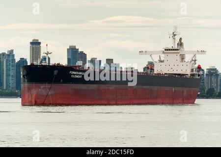 Bulk Carrier 'Formosabulk Clement' (2001) wartet auf Be- und Entladung im Hafen von Vancouver vor der Skyline von Vancouver. Stockfoto