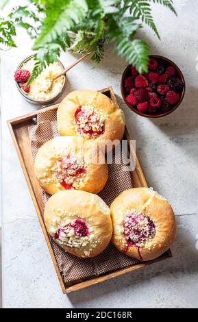 Hausgemachte süße Hefegebrüse gefüllt mit Beeren und mit Krümel. Betonboden. Stockfoto