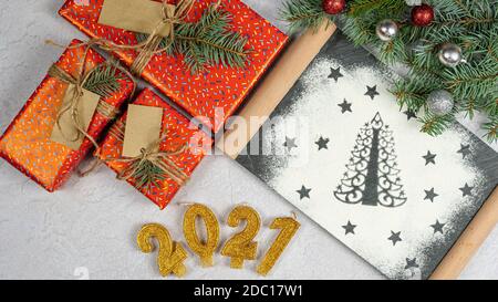 Silhouette von Weihnachtsbaum aus Mehl. Feiertagshintergrund mit dem Text der goldenen Zahl 2021, Geschenkbox und Baumzweig, Draufsicht. Konzept von Stockfoto