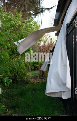 Weiße Vorhänge auf einer Terrasse im Freien weht heftig in die Wind Stockfoto