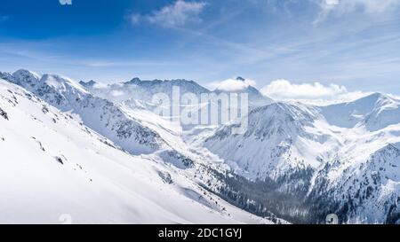 Blick von Kasprowy Wierch auf Kiefernwald mit Winterüberzug im Tal. Schneebedeckte Berggipfel der Tatra, Bukowina Tatrzanska, Polen Stockfoto