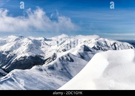 Blick von Kasprowy Wierch auf Kiefernwald mit Winterüberzug im Tal. Schneebedeckte Berggipfel der Tatra, Bukowina Tatrzanska, Polen Stockfoto