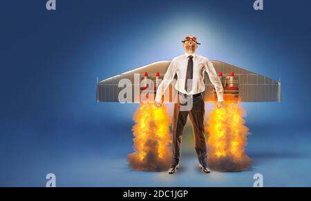 Geschäftsmann mit Flügeln und Fackeln auf dem Rücken mit Flammen und Rauch. Konzept der Bestrebungen und Erfolg. Start up. Stockfoto