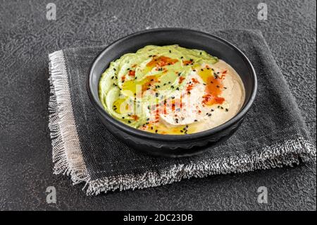 Schale aus Guacamole und Hummus auf schwarzem Hintergrund Stockfoto