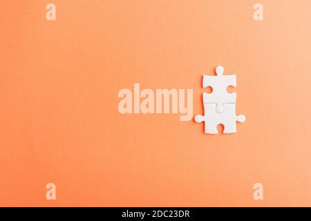 Draufsicht flach Lay von zwei Papier schlichten weißen Puzzle-Spiel letzte Stücke für lösen, Studio auf einem orangen Hintergrund erschossen, Quiz Berechnung Konzept Stockfoto