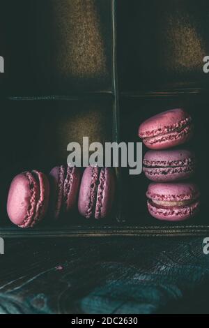 Traditionelle französische mehrfarbige Makkaroni in einer Holzkiste auf dem Tisch. Schöne romantische Dessert von Mandelkuchen, eine Kopie des Raumes Stockfoto