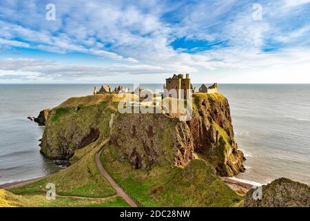 DUNNOTTAR CASTLE STONEHAVEN ABERDEENSHIRE SCHOTTLAND WANDERWEG FÜHRT ZU SCHLOSSGEBÄUDEN AN STEILEN KLIPPEN Stockfoto