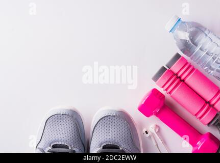 Paar Sportschuhe, Kopfhörer, Hantel und Wasserflasche auf weißem Hintergrund, Grau Sneaker und Zubehör Geräte in Fitness-STUDIO, gesundes Training Stockfoto