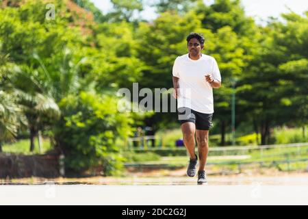 Asiatische junge Lifestyle-Sportler Sport Läufer schwarz Mann tragen Füße Schuh aktiv Lauftraining im Freien auf dem Laufband Linie Straße, gesunde exercis Stockfoto