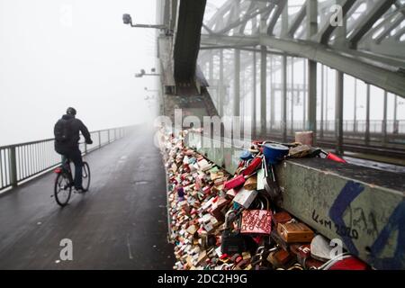Vorhängeschlösser am Zaun des Fußweges der Hohenzollerneisenbahn-Brücke, Nebel, Köln, Deutschland. Vorhaengeschloesser als Liebessschloesser am Zaun entlang des Stockfoto