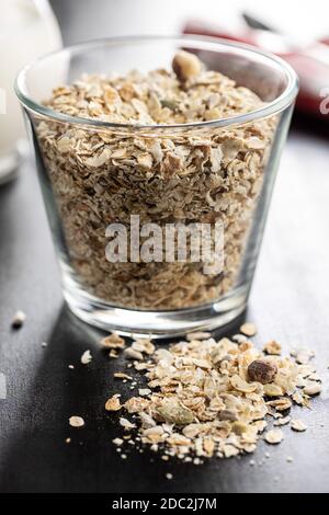 Müsli, Cerealien. Gesundes Frühstück mit Haferflocken auf schwarzem Tisch. Stockfoto
