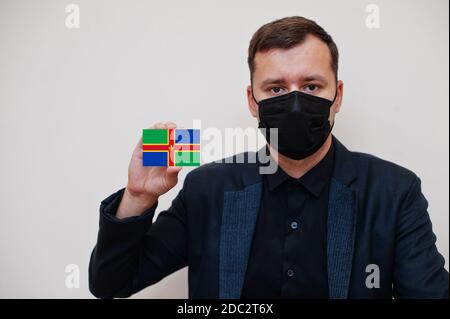 Mann tragen schwarz formell und schützen Gesichtsmaske, halten Lincolnshire Flagge Karte isoliert auf weißem Hintergrund. Vereinigtes Königreich Grafschaften England Coronavirus Stockfoto