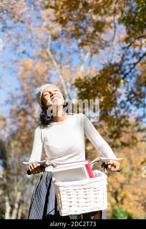 Brunette Mädchen genießen eine Radtour an einem Herbsttag. Leerzeichen für Text. Stockfoto