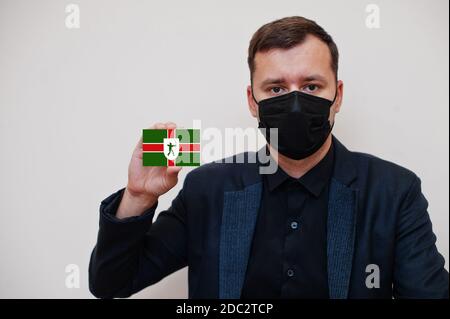 Mann tragen schwarz formell und schützen Gesichtsmaske, halten Nottinghamshire Flagge Karte isoliert auf weißem Hintergrund. Vereinigtes Königreich Grafschaften von England coronavir Stockfoto