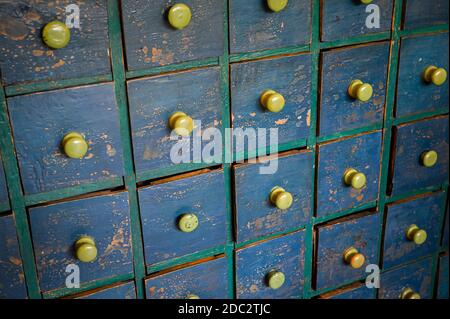 Reihen von kleinen hölzernen Schubladen mit einer verzweifelten Lackierung. Stockfoto