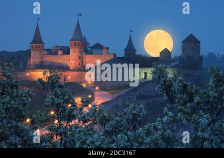 Nachtlandschaft mit Vollmond über der Festung. Beleuchtung auf einem historischen Gebäude. Historisches Wahrzeichen Stockfoto