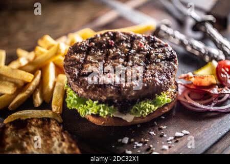Klassischer Rindfleischburger mit Salatzwiebel und pommes frites Stockfoto